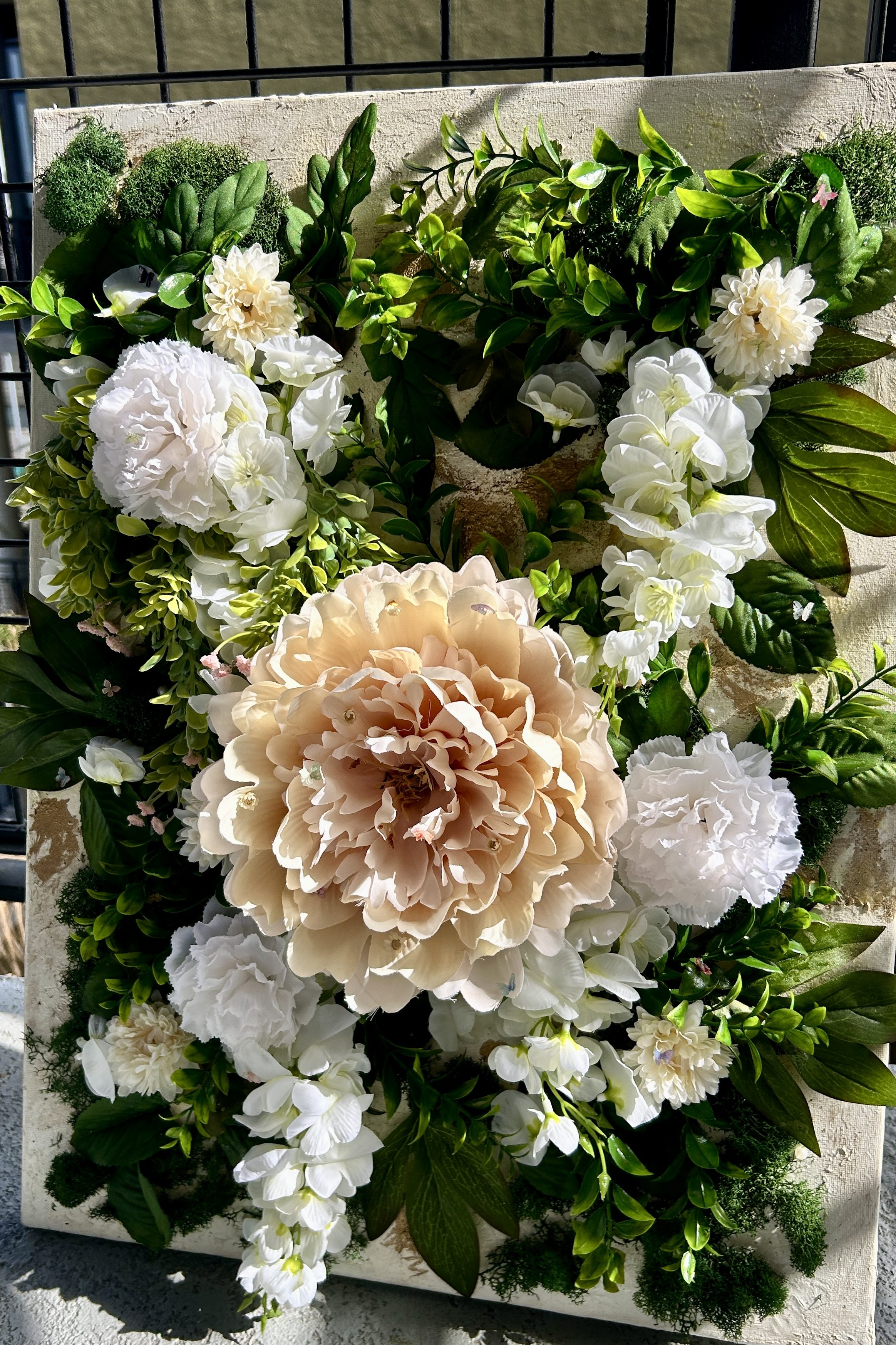 Mixed media collage artwork featuring an artificial flower arrangement by Katherine Elizabeth Jackson